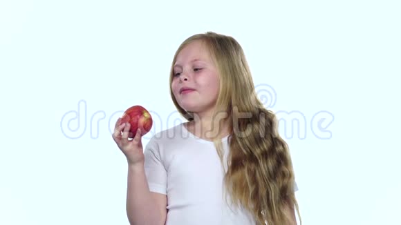 孩子咬苹果很好吃白色背景慢动作视频的预览图