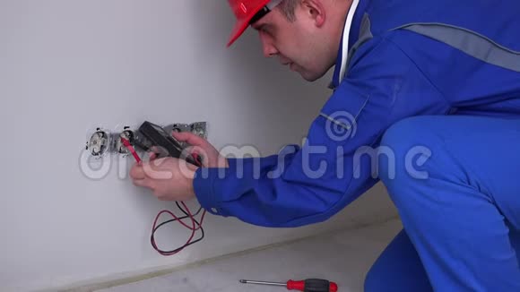 白人电工在墙上插座上工作视频的预览图