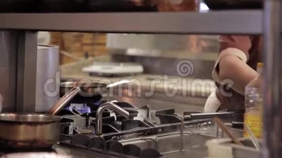 厨师在厨房餐厅的煎锅里加入面粉视频的预览图
