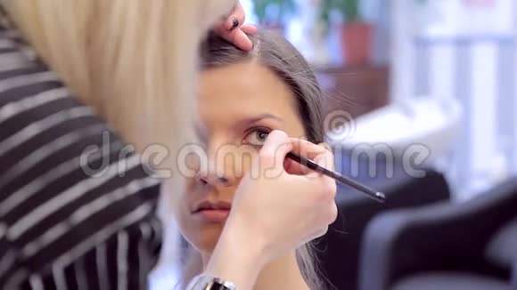 化妆师用线条勾勒出年轻模特的眼睛视频的预览图