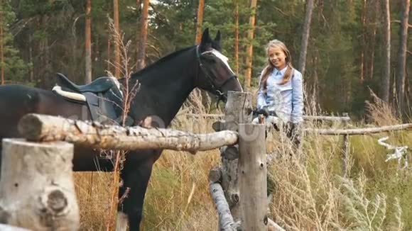 女孩和马之间的爱和理解红发女孩和棕色的马在森林里视频的预览图