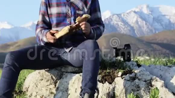 自然界中英俊的秃头徒步旅行者在美丽的山景中吃面包视频的预览图