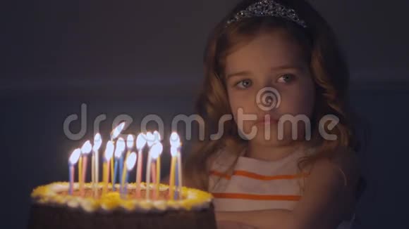 一个悲伤的小女孩看着生日蛋糕许愿让爸爸回家慢动作视频的预览图