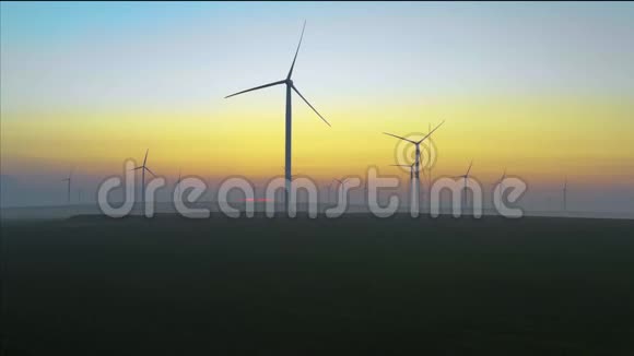 风力涡轮机的空中视图能源生产风车在日出时拍摄风能农场在一个美丽的环境中的欧洲发电机视频的预览图