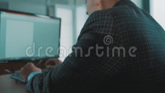办公室职员穿着格子夹克疲倦地在电脑键盘上打字视频的预览图
