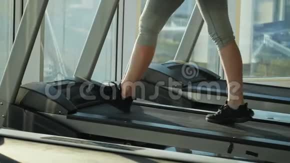 有魅力的中年妇女正在体育健身中心的跑步机上跑步视频的预览图