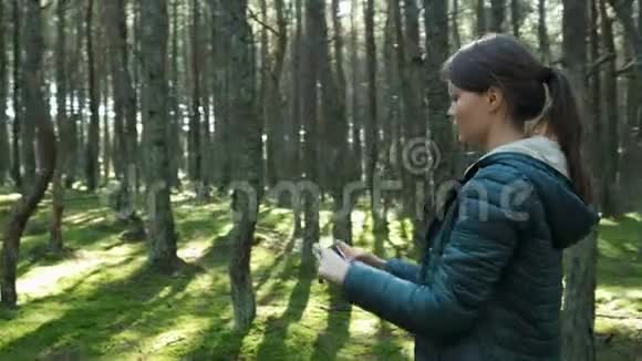 女人打电话给森林里的树木拍照视频的预览图