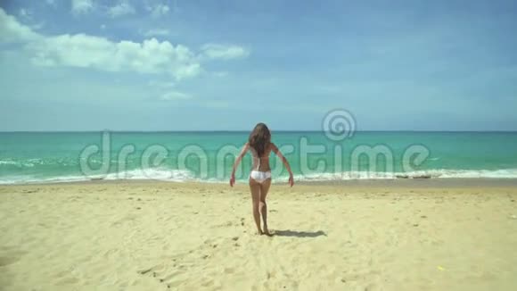 年轻女子在沙滩上举起手臂视频的预览图