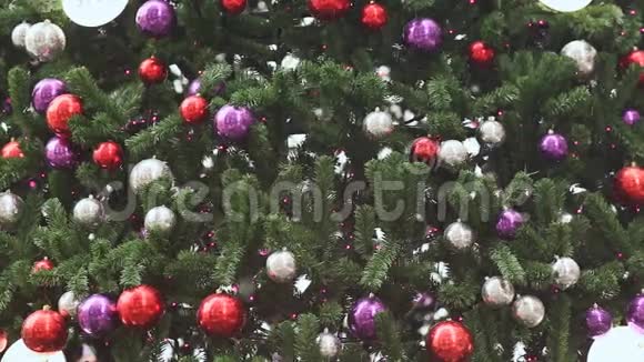 彩色气球里的圣诞树下雪了特写背景新年主题视频的预览图