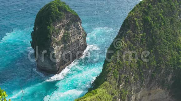 印度尼西亚巴厘努沙佩尼达岛Kelingking海滩岩石形成周围的海浪视频的预览图