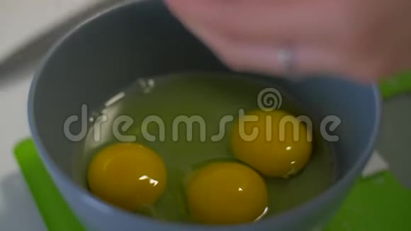 雌性的手把鸡蛋打碎倒入盘子里视频的预览图
