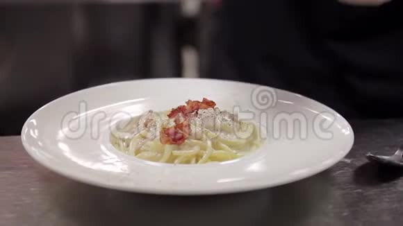 厨师在餐厅的厨房里用新鲜的沙拉装饰了现成的卡拉视频的预览图