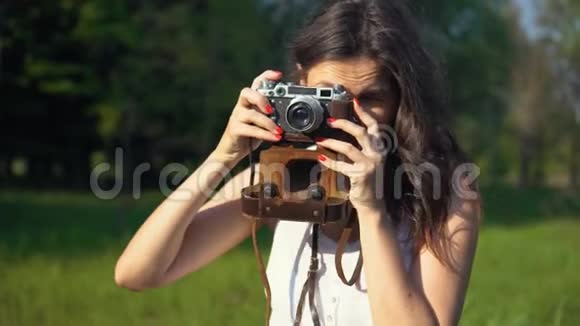 年轻女性摄影师在户外用相机拍照视频的预览图