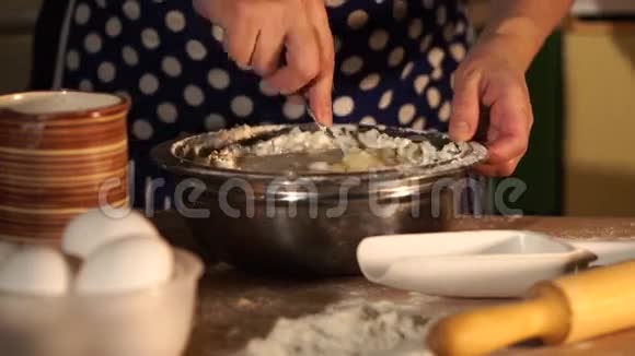 家庭主妇把面粉和鸡蛋混合成面团的双手合拢视频的预览图