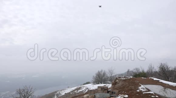 无人机在山上飞行云天雪天为拍摄目的而玩无人驾驶飞机的人视频的预览图