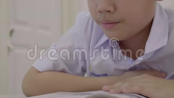 亚洲孩子穿着学生制服读写做家庭作业视频的预览图