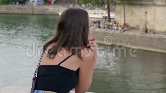年轻的法国女人在巴黎塞纳河放松视频的预览图