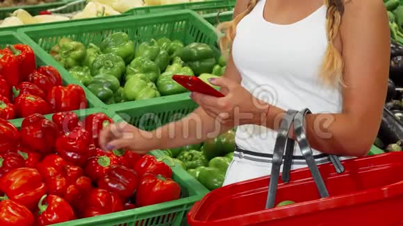在超市购物时使用智能手机的女人视频的预览图