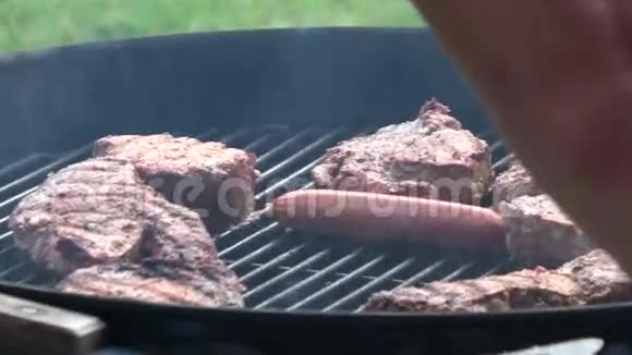 男人用烤架做牛排和香肠视频的预览图