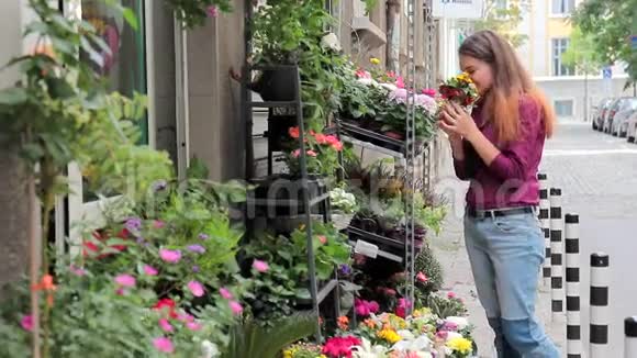 街头商店鲜花一个年轻女子选择花束视频的预览图