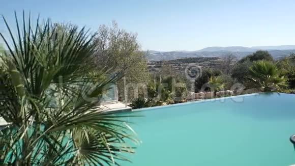 游泳池附近有山和热带棕榈的美丽景色视频的预览图