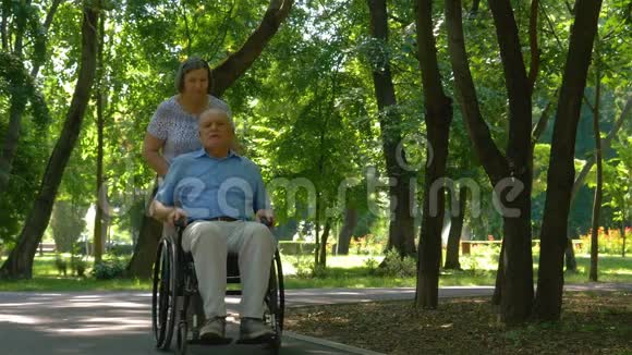 把丈夫推在轮椅外面的老女人视频的预览图
