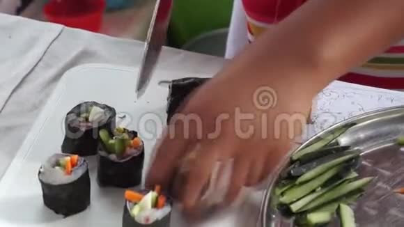 一年一度的烹饪比赛中小女孩切鱼寿司卷视频的预览图
