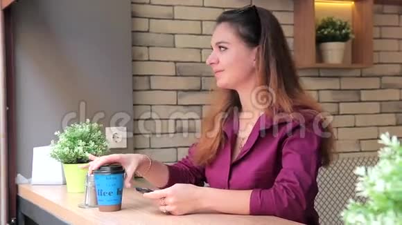 在户外咖啡馆休息时喝咖啡的年轻女子视频的预览图