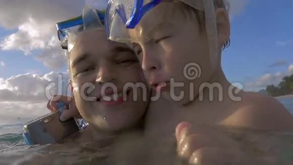 毛里求斯岛路易斯港带着戴着浮潜面具的儿子在水中快乐的年轻父亲的慢镜头视频的预览图