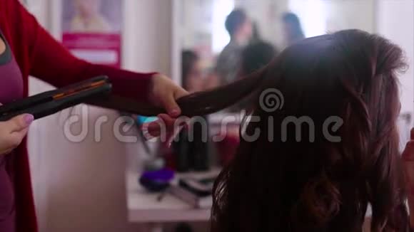 发型师做头发的特写镜头用发铁做慢动作视频的预览图