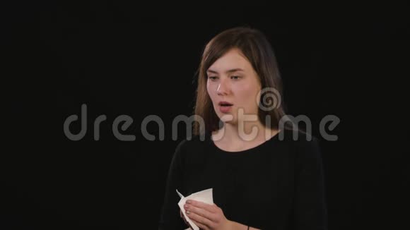 一位女士在黑色背景下吹鼻子视频的预览图