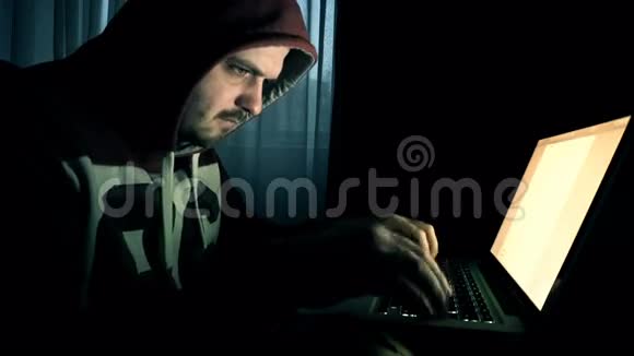 头罩里的男黑客在电脑上工作视频的预览图