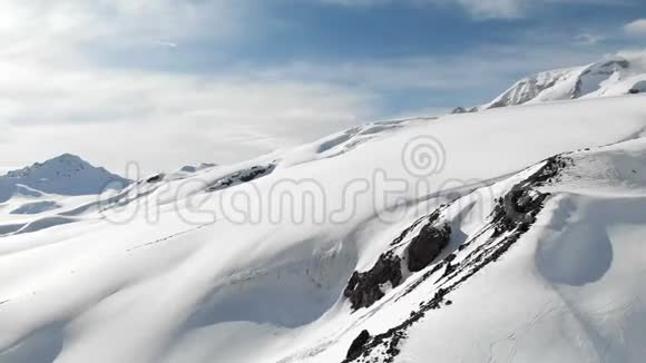 鸟瞰冬山景观埃尔布鲁斯南部度假胜地积雪覆盖的岩石斜坡视频的预览图