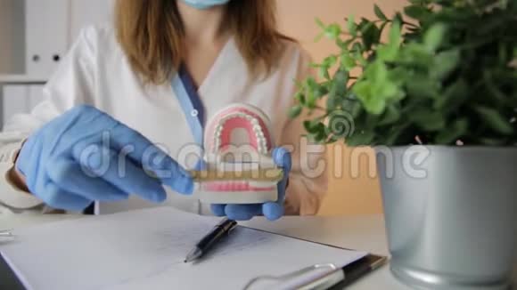 女牙医拿着专业的口腔医学工具指着牙齿模型牙科卫生及健康概念视频的预览图