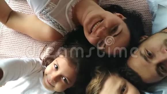 美丽幸福的家庭母亲父亲儿子和女儿手里拿着礼物在地板上视频的预览图