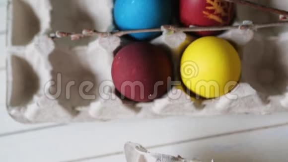 复活节彩蛋放在一个篮子里放在乡村木制的背景上白色背景上的多色复活节彩蛋快乐的复活节视频的预览图