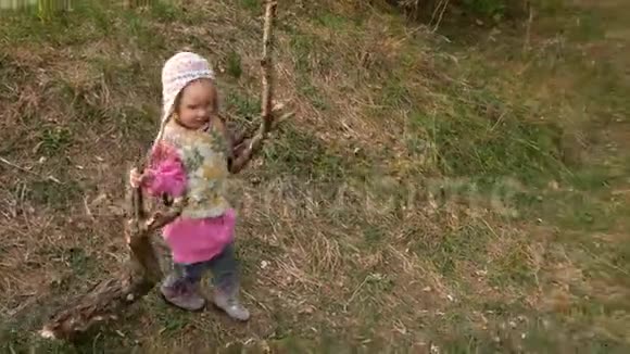 一个女孩在森林里拾柴孩子把木头带到火里视频的预览图