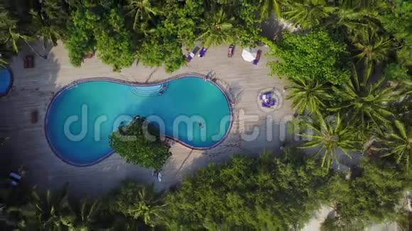 马尔代夫岛的俯视图中豪华酒店的游泳池上方正升起摄像机有很多度假胜地的空中录像视频的预览图