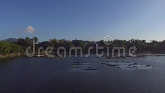 太阳升起在桑帕洛克湖定居点树木和植被沿山湖岸视频的预览图