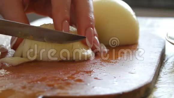 女用手用刀在菜板上切一个大洋葱视频的预览图