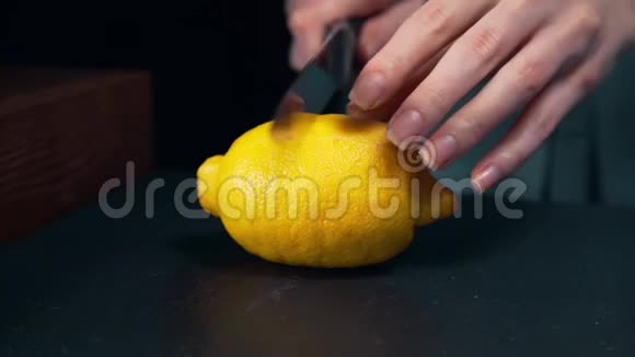 厨师把柠檬切成两半水果沙拉女孩准备新鲜饮料龙舌兰柠檬厨房里的水果视频的预览图