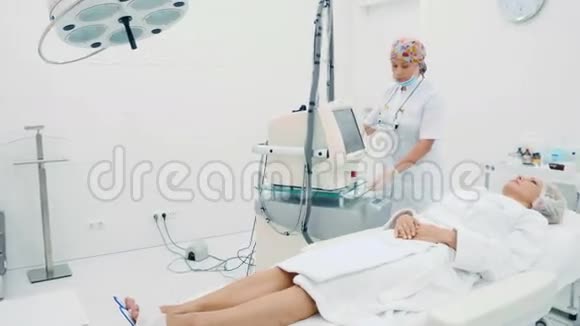 美容师在诊所为妇女准备非侵入性手术视频的预览图
