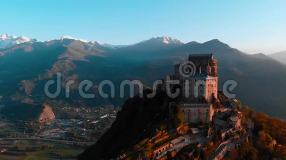 空中飞行无人驾驶飞机在古老的中世纪修道院栖息在山顶背景雪阿尔卑斯山在日出意大利圣米歇尔视频的预览图