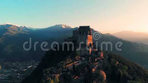 空中飞行无人驾驶飞机在古老的中世纪修道院栖息在山顶背景雪阿尔卑斯山在日出意大利圣米歇尔视频的预览图