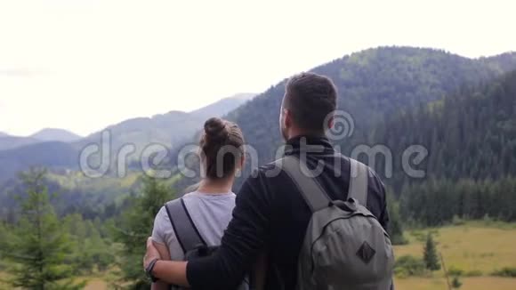 一对夫妇爬上山脉高兴地举起双手视频的预览图