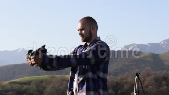 人用专业的电影相机在山景拍摄自拍照片视频的预览图