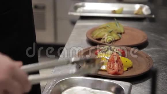 厨师躺在盘子里蔬菜在现代化的大厨房烤架上煎视频的预览图