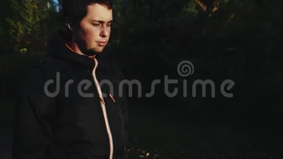 年轻的悲伤体贴的沮丧男人穿着黑色夹克走在街上视频的预览图