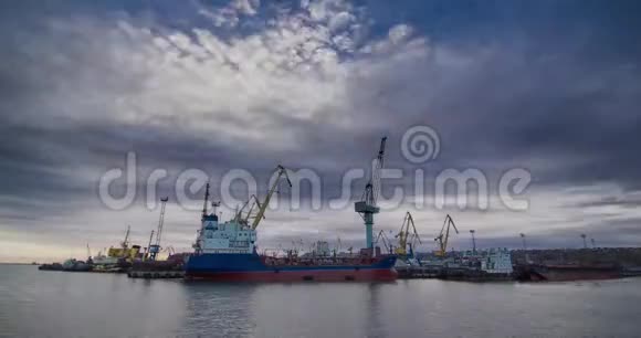 日落时有货物起重机和铁路集装箱货车的工业海运码头岸边起重机在视频的预览图