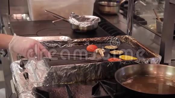 餐厅的厨师转动长钳烤蔬菜视频的预览图